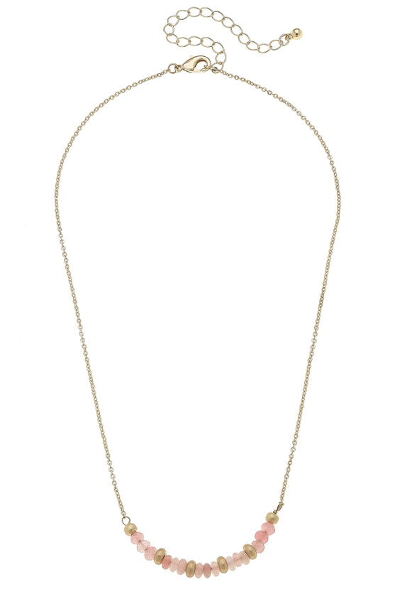 Necklace with pink beads in s crescent shape on a gold chain.